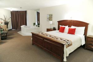 a bedroom with a large bed and a bath tub at Excelsior Hôtel Spa Sainte-Adèle in Sainte-Adèle