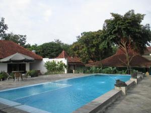 日惹Alam Jogja Resort Mitra RedDoorz的房屋前的游泳池