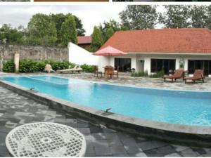 日惹Alam Jogja Resort Mitra RedDoorz的房屋前的游泳池