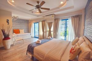 um quarto com uma cama grande e uma ventoinha de tecto em Blu Beach Haven em Hua Hin