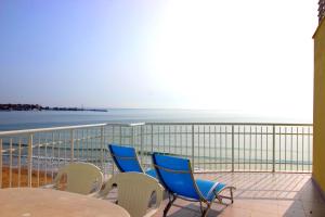 a balcony with chairs and a table and the ocean at Perla Apartments First Line in Nesebar