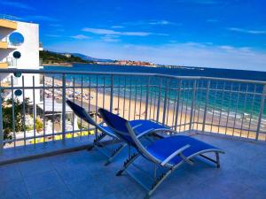 a pair of chairs sitting on a balcony overlooking the beach at Perla Apartments First Line in Nesebar