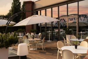 ein Restaurant mit Tischen, Stühlen und Sonnenschirmen auf einer Terrasse in der Unterkunft Hotel Bulwar in Toruń