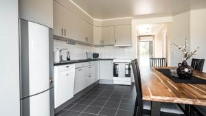 a kitchen with white cabinets and a wooden table at Saxnäs Ferieboende L. Erik in Färjestaden