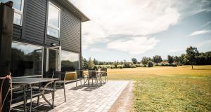 a patio with a table and chairs on the side of a house at Saxnäs Ferieboende L. Erik in Färjestaden