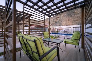 a patio with chairs and a table and a pool at Riyam Hotel in Muscat