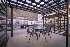 a patio with a table and chairs and a pool at Riyam Hotel in Muscat