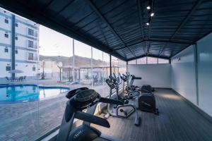 a gym with bikes parked next to a swimming pool at Riyam Hotel in Muscat