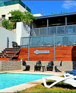 - une piscine avec des chaises et une table à côté d'un bâtiment dans l'établissement Apart Porto del Sol by CPH, à Villa Carlos Paz