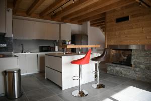 cocina con 2 taburetes y chimenea en Le Mazot d'la Marmotte T3, en Passy