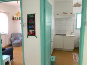 een keuken met een deur naar een woonkamer bij Casa do Viajante - Family in Zambujeira do Mar