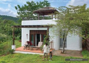 a family standing in front of a small house at The Serai Bandipur in Bandipūr