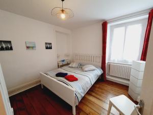 een slaapkamer met een bed met een rood shirt erop bij Les Sablons - Très Bel Appartement , Lumineux in Saint-Malo