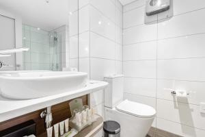 a white bathroom with a sink and a toilet at Holiday Inn Queenstown Frankton Road, an IHG Hotel in Queenstown