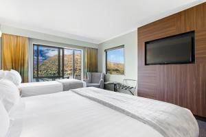 a hotel room with two beds and a flat screen tv at Holiday Inn Queenstown Frankton Road, an IHG Hotel in Queenstown