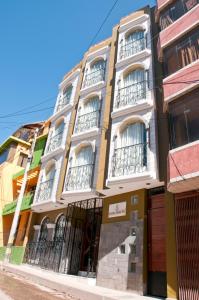 a tall building with balconies on a street at UTASA VILLA REAL inn in Puno