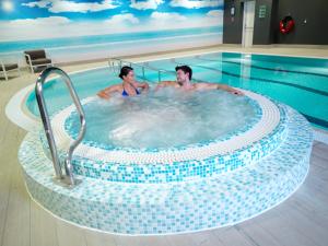 twee mannen in een bubbelbad in een zwembad bij Crowne Plaza Nottingham, an IHG Hotel in Nottingham