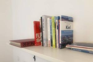 a row of books sitting on a shelf at Gemütliche sanierte 1 Zimmer Wohnung mit privatem Parkplatz im Zentrum in Kiel