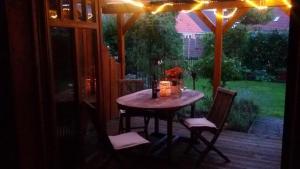 een houten tafel en stoelen op een veranda met een tafel en een raam bij Reuken - Fewo Zum Emslotsen in Emden