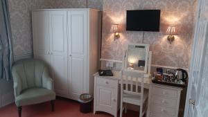 a room with a desk and a chair and a tv at Bryn Derwen with Private Car Park in Llandudno