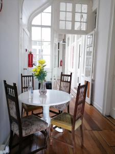 une salle à manger avec une table et des chaises blanches dans l'établissement Casa Capilla, à Valparaíso