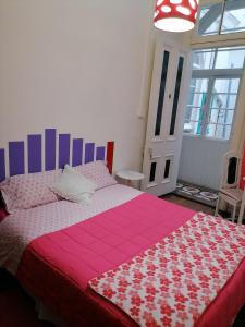 - une chambre avec un grand lit et une couverture rose dans l'établissement Casa Capilla, à Valparaíso