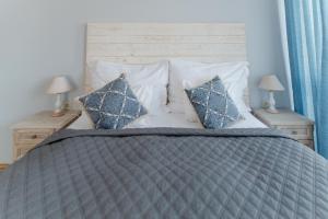 a bedroom with a bed with blue and white pillows at Aurora Vendégház in Hévíz