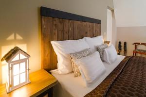 a bedroom with a bed with a wooden headboard and pillows at Aurora Vendégház in Hévíz