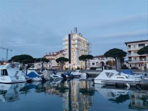 un grupo de barcos atracados en un puerto con un edificio en Hotel Mare, en Lignano Sabbiadoro