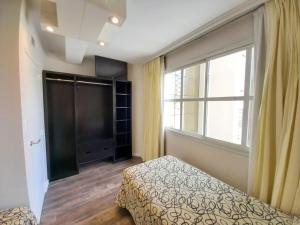 1 dormitorio con cama y ventana grande en Hotel Versailles, en Mar del Plata