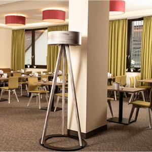 une salle à manger avec des tables, des chaises et une lampe dans l'établissement Hotel am Berg Esslingen, à Esslingen am Neckar