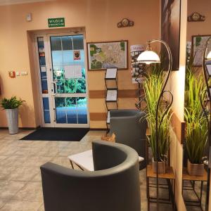 un vestíbulo con sillas y plantas frente a una puerta en Hotel Helena, en Giżycko