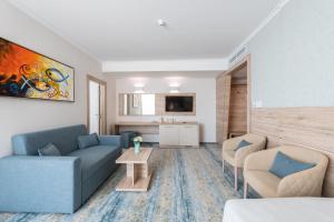 salon z niebieską kanapą i 2 krzesłami w obiekcie Hotel Neptun Beach w Słonecznym Brzegu