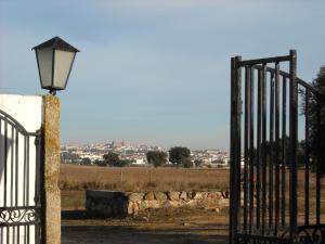 um portão com uma luz de rua ao lado de uma cerca em Monte Da Serralheira Agro Turismo em Évora