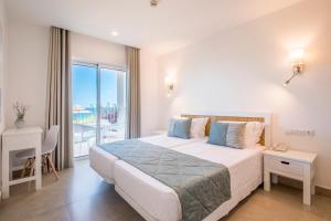 Clube Porto Mos - Sunplace Hotels & Beach Resort في لاغوس: غرفة نوم بسرير كبير وبلكونة