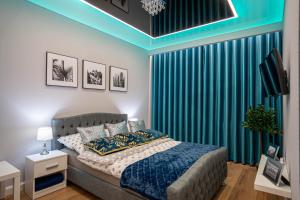 NEW Apartament VIP BLUE Warszawa+PARKING في Wola Mrokowska: غرفة نوم بسرير وستارة خضراء