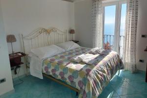 una camera con letto e vista sull'oceano di Villa Casola B&B a Positano