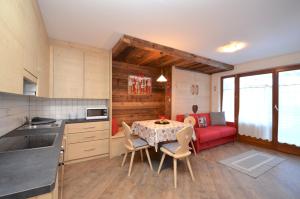 a kitchen and dining room with a table and a red couch at Aurturist S Candido Roulette in San Candido