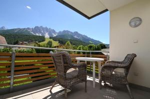 two chairs and a table on a balcony with mountains at Aurturist S Candido Roulette in San Candido