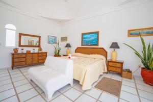 1 dormitorio con 1 cama y 1 silla blanca en Villas Fasol Huatulco, en Santa Cruz Huatulco