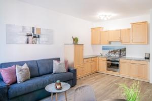 salon z niebieską kanapą i kuchnią w obiekcie Laube35 Central City Apartments w mieście Vipiteno