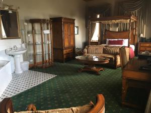 a bedroom with a bed and a couch and a table at Denison Boutique Hotel in Rockhampton