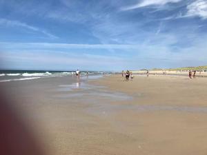 un groupe de personnes marchant sur la plage dans l'établissement Duenenhof-zum-Kronprinzen-Appm-60, à Wenningstedt