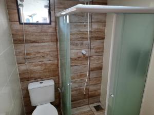 e bagno con servizi igienici e doccia in vetro. di Alice Suites ad Arraial do Cabo