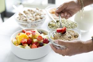 um grupo de pessoas comendo uma tigela de frutas e cereais em Johannesbad Hotel Füssinger Hof em Bad Füssing