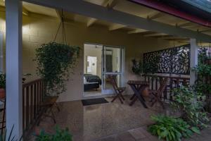 a porch of a house with chairs and a mirror at Kookaburra Motel Yungaburra in Yungaburra