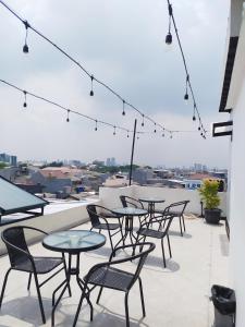 een patio met tafels en stoelen op een dak bij Puri Maju Hotel in Jakarta