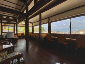 een restaurant met stoelen en ramen met uitzicht bij Ryoso Kawaguchi in Miyajima