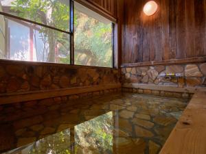 een kamer met een stenen vloer en een raam bij Ryoso Kawaguchi in Miyajima