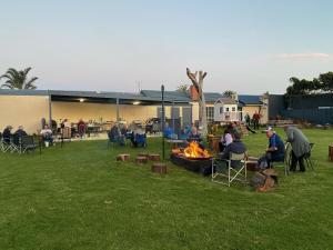 Eine Gruppe von Menschen, die in einem Hof um ein Feuer herum sitzen in der Unterkunft Lakeside Motel Waterfront in Lakes Entrance